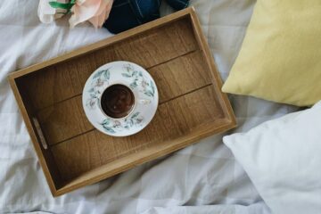white and brown ceramic teacup on brown wooden tray